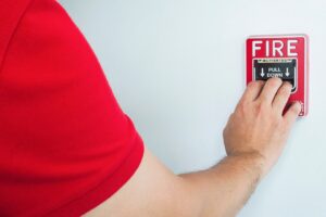 man-is-reaching-his-hand-push-fire-alarm-hand-station